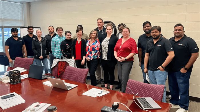The Express Automation Solutions team standing together around a conference table